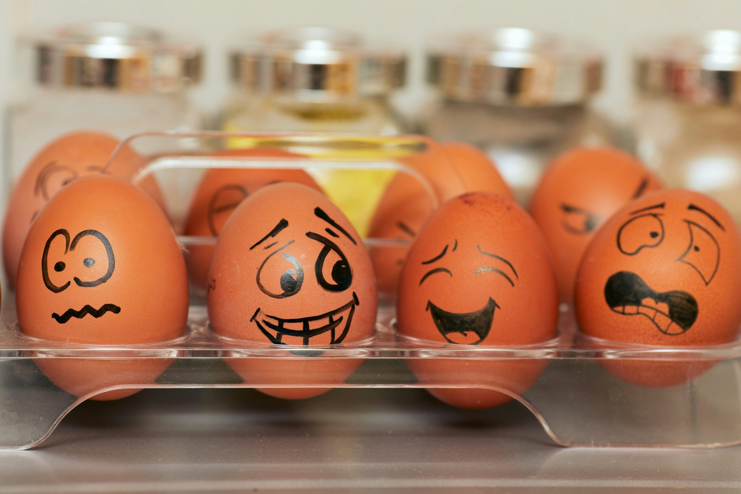 A carton of eggs with faces drawn on.